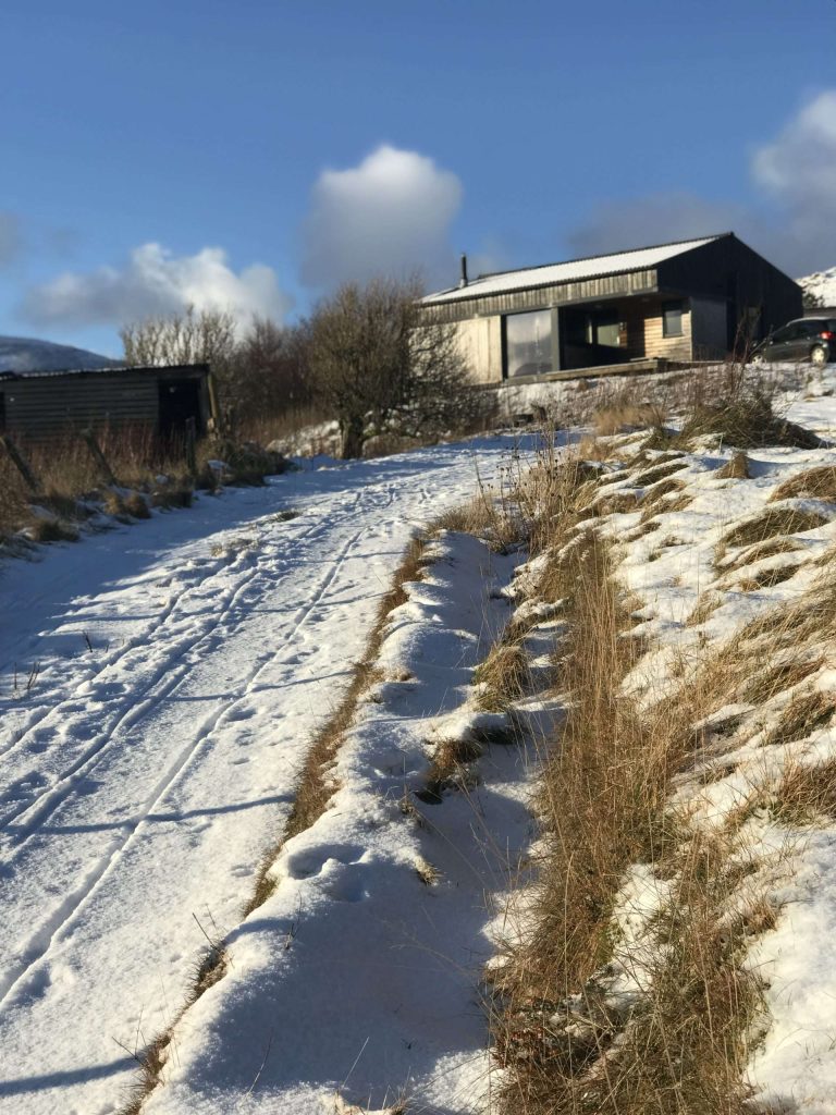 A photograph looking up the track which leads up to The Black Shed, covered in snow. 