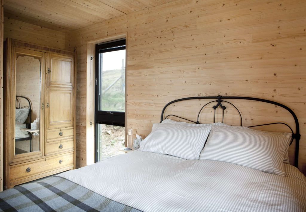 A wide angle shot of the bedroom, showing the antique wardrobe which features in the room. 